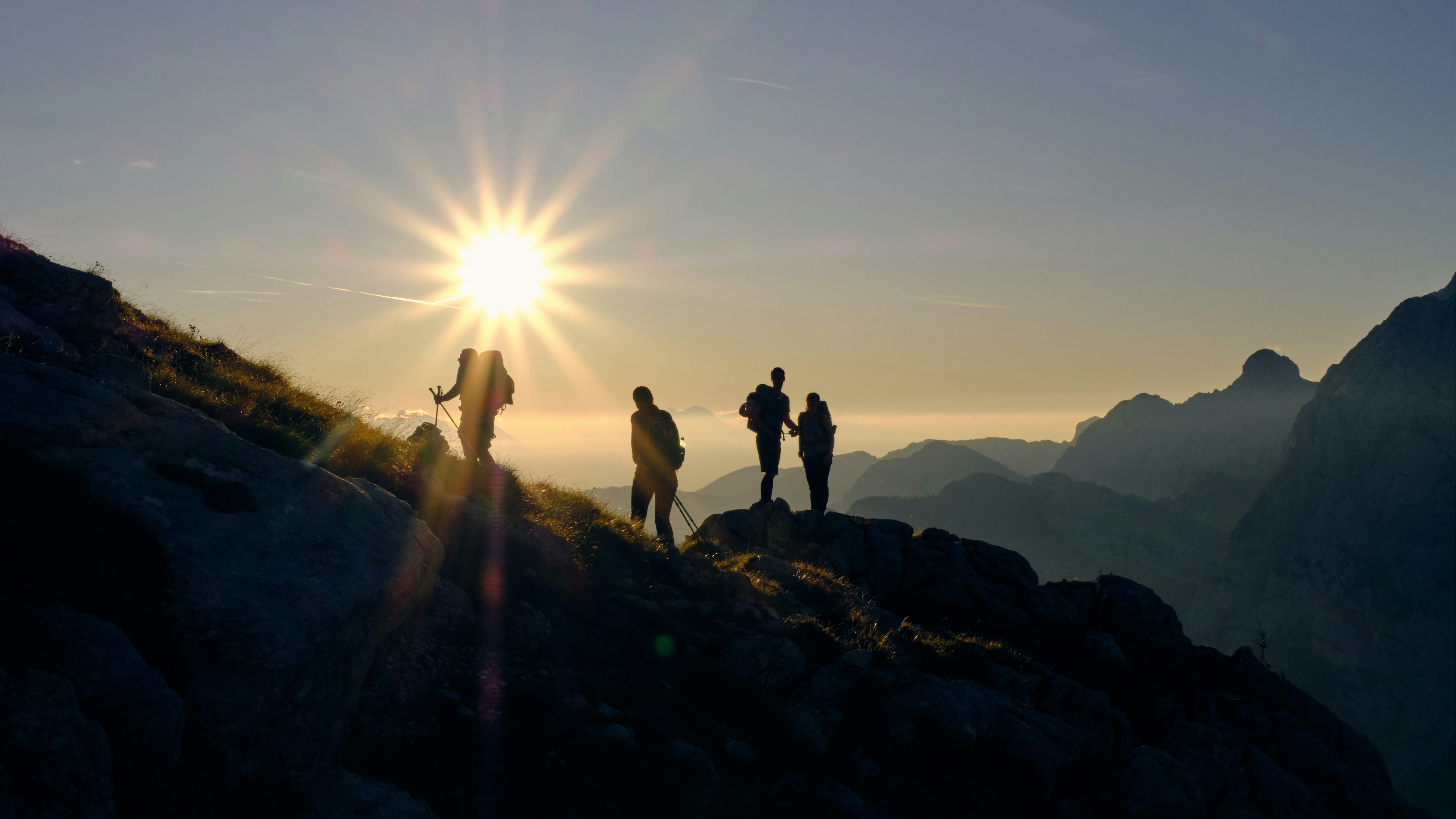 Four hikers on a mountain during daytime